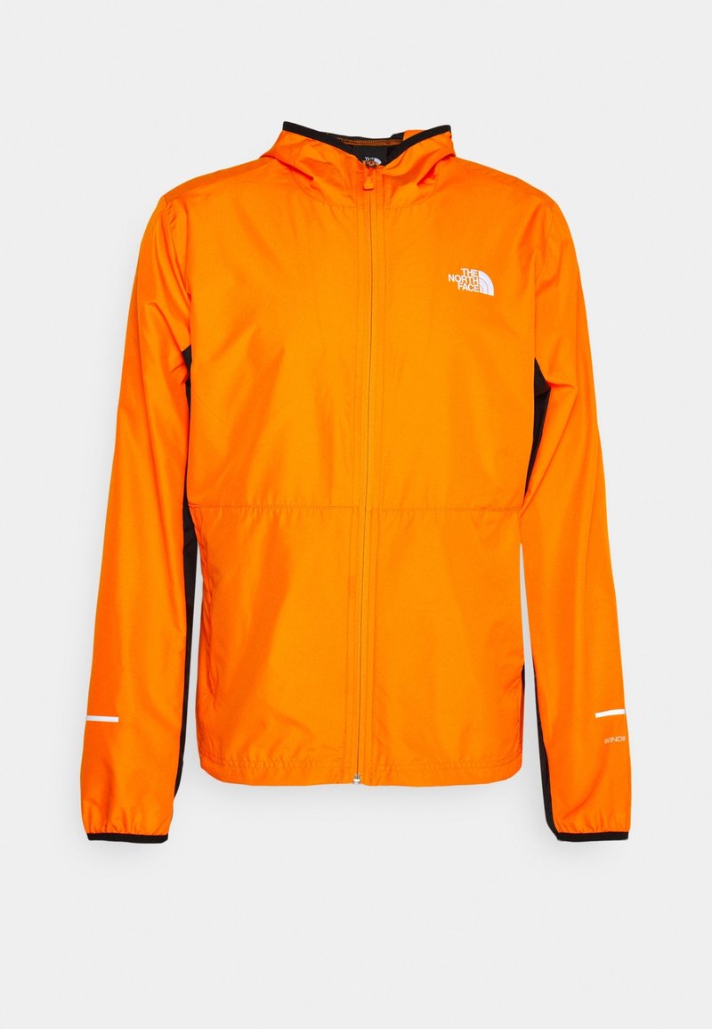 Veste légère orange vif avec capuche, fermeture éclair complète à l'avant, panneaux latéraux noirs et logo blanc The North Face sur la poitrine.