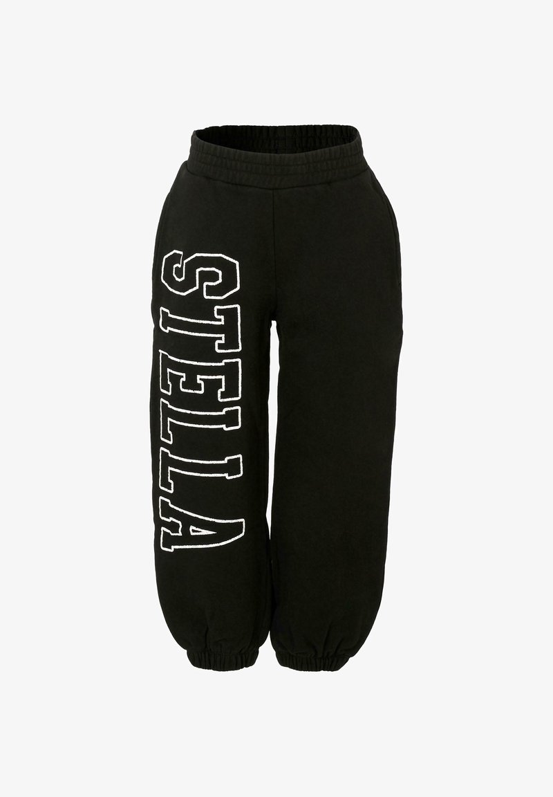 Pantalons de sudation noirs avec une taille élastique, des poignets effilés et le texte blanc "STELLA" imprimé verticalement sur le côté. Fabriqués en coton doux.