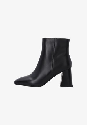 Bottines noires en cuir lisse avec un bout pointu et un large talon bloc. Design sans couture, sans matériel ni accents visibles.