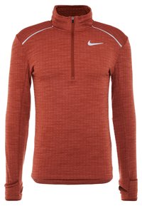 Langärmliger, rostfarbener Sportpullover mit Viertelreißverschluss, Daumenlöchern und einem weißen Nike-Logo auf der Brust.