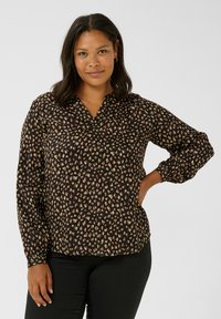 Black blouse featuring a v-neck, long puff sleeves, and a pattern of beige and brown abstract shapes throughout the fabric.