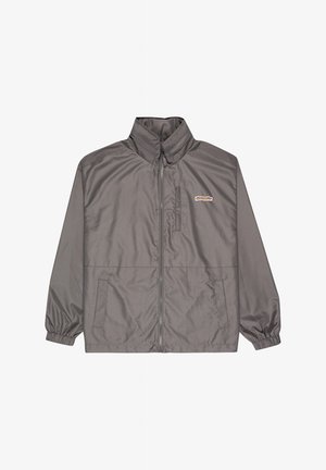 Chaqueta gris con cremallera, cuello alto, puños elásticos, dos bolsillos delanteros y pequeño parche rectangular con logotipo en el pecho izquierdo.