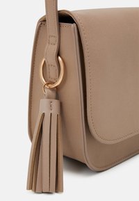 Hnědá ramenní taška s hladkým povrchem, zlatým kováním ve tvaru kruhu a detailem s třásněmi. Obsahuje klopu na zavírání a prošívané okraje.