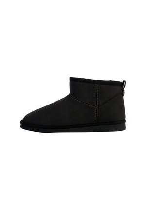 Botas negras de ante de altura al tobillo, con un suave forro interior, que presentan un diseño de costura texturizada y suela plana de goma.