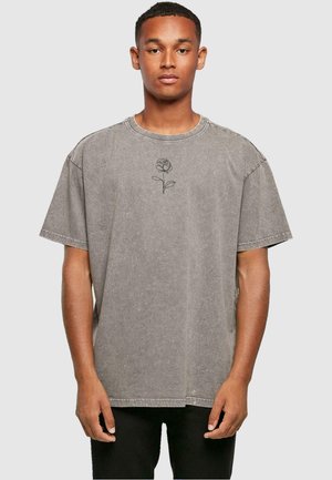 Gray oversized t-shirt made of cotton, featuring a simple black rose embroidery on the chest and a round neckline.