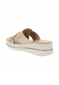 Infradito beige chiaro con due ampie cinghie e design perforato. Soletta imbottita su una spessa suola bianca con un'accents metallici.