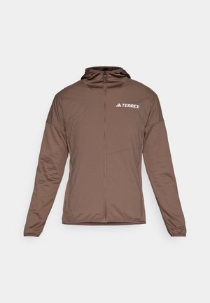 Brun zip-up jakke med lange ermer, frontlås og hette. Har en jevn tekstur og "TERREX"-logo i hvitt på brystet.
