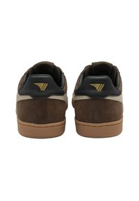 Sneaker in suede marrone con dettagli in pelle nera e un logo dorato sul tallone. Presentano una suola in gomma e un collo imbottito per il comfort.