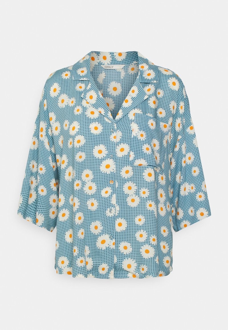 Chemise bleue à manches courtes avec boutons, motif floral marguerite blanche et jaune et petite poche poitrine.
