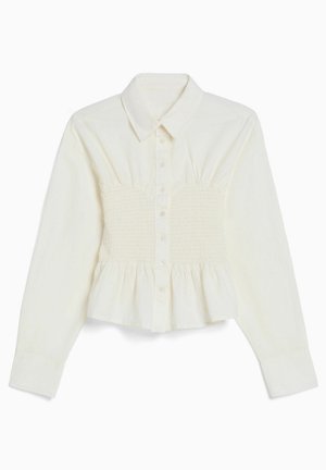 Hvid bluse med lange ærmer, knapper, krave, smocket talje og peplumkant.