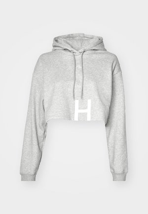 Pelēks īss kapucis ar savelkamu kapuci, garām piedurknēm un izteiktu baltu "H" logotipu priekšpusē. Mīksta auduma faktūra.
