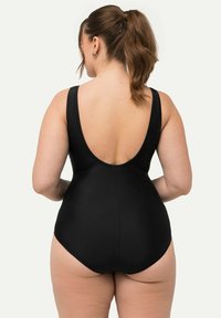 Maillot de bain une pièce noir avec un design à dos décolleté et de larges bretelles, fabriqué dans un matériau lisse et extensible.