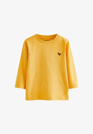 T-shirt giallo a maniche lunghe realizzato in tessuto morbido, con scollatura tonda e un piccolo logo di un dinosauro nero sul petto.