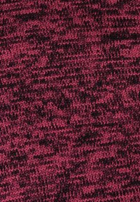 Tejido de punto en una mezcla de rosa oscuro y negro. Presenta un patrón texturizado con tonos variables y sutiles transiciones de color a lo largo.