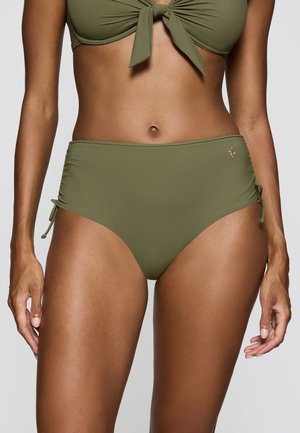 Kobieta nosząca oliwkowo zielone majtki bikini z wysokim stanem i wiązaniami po bokach oraz dopasowany top bikini zawiązany z przodu, pokazana od połowy tułowia do ud.