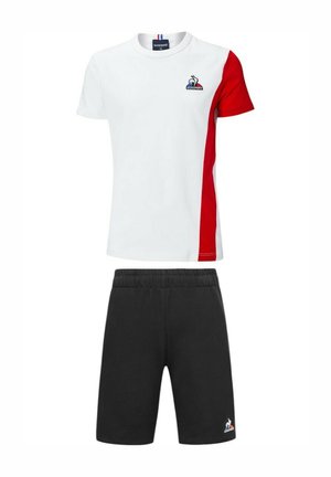 Camiseta blanca con panel lateral rojo, logo en el pecho; pantalones cortos atléticos negros con cintura elástica y logo. Material de mezcla de algodón.