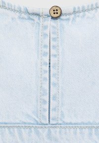 Lichtblauwe denimstof met een verticale naad en een enkele ronde, bruine knop aan de bovenkant. Bevat contrasterende stiksels langs de naad.