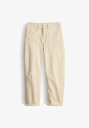 Beige high-waist pants with a button and zipper closure, two large front pockets, belt loops, and rolled-up cuffs.