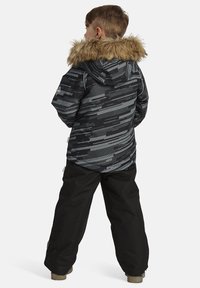 Mustra mustern ja talvejope musta ja halliga, ees on vale karvakaelus, koos mustade pükstega. Omab siledat tekstuuri ja kihilist disaini.