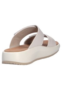Sandalias de un tono beige claro con dos tiras cruzadas, plantilla acolchada y una suela de plataforma blanca gruesa con agarre texturizado.