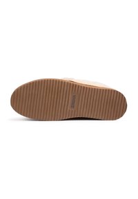 Chaussures avec une semelle en caoutchouc brun texturé, dotée de rainures pour une meilleure traction. La partie supérieure est de couleur claire avec une finition lisse et des accents minimalistes.