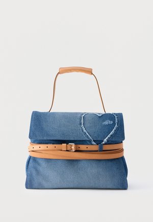 Sac à main en denim bleu avec poignée en cuir beige et ceinture, présentant un détail cœur cousu sur le rabat avant.