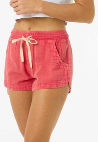 Shorts in cotone rosa con una vestibilità rilassata, vita elastica e cordino beige. Presentano tasche frontali e un tessuto texturizzato con un motivo sottile.