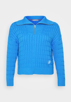 Strikket blå pullover med lynlåskrave. Har et tekstureret mønster og ribbede manchetter. Lille logo detalje på forsiden. Materiale af bomuldsblanding.