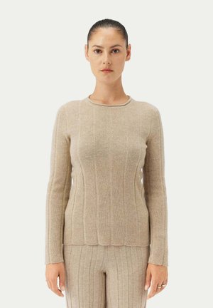 Beige gestrickter Pullover mit Rippstruktur, rundem Ausschnitt und langen Ärmeln. Mit Wellenkante und taillierter Silhouette.