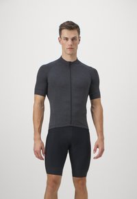 Maillot de cyclisme gris charbon à manches courtes avec une fermeture éclair à l'avant, associé à un short rembourré noir. Design ajusté avec une texture lisse.