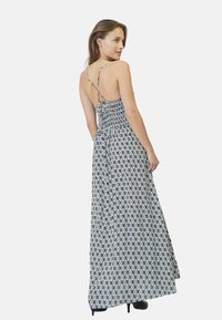 Rochie maxi cu un model alb și negru, având un corset elastic, spate deschis și bretele subțiri reglabile. Materialul este ușor și fluid.