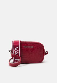 Červená crossbody kabelka z kůže s reliéfem krokodýla, s odnímatelným popruhem a výrazným logem Valentino ve stříbrném kování. Obdélníkový tvar.