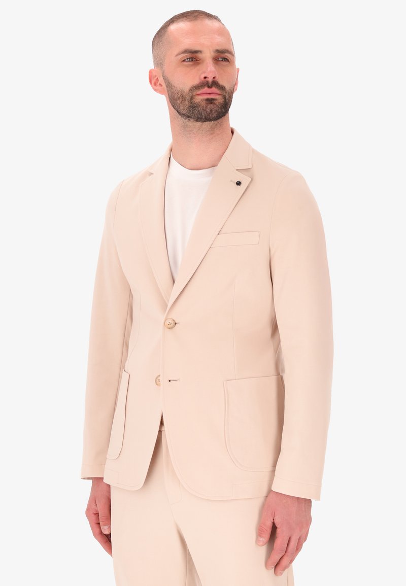 Blazer beige realizzato in tessuto liscio, dotato di due tasche frontali, chiusura con bottoni e rever a punta. Design semplice con accenti minimi.