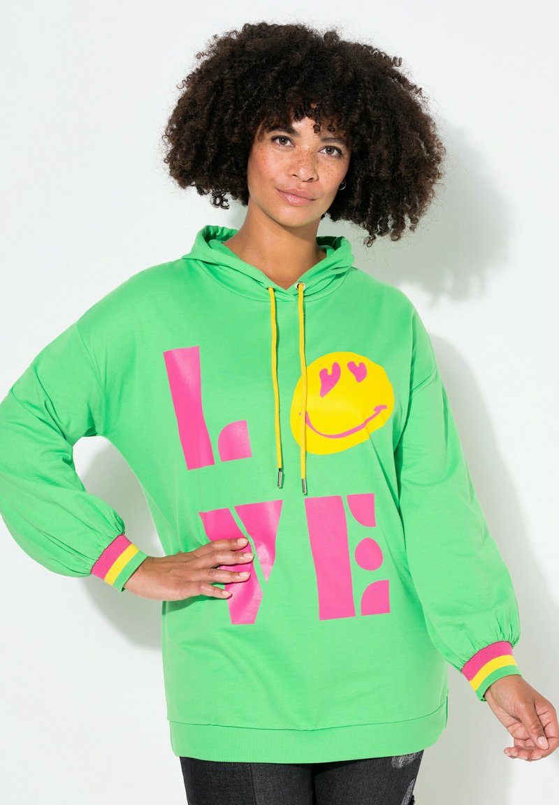 Felpa con cappuccio verde con testo rosa brillante "LOVE" e faccina sorridente gialla. Presenta lacci gialli e polsini a righe multicolori.
