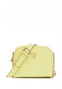 Żółta torebka pikowana z złotymi elementami, regulowanym paskiem i plakietką z logo na przodzie. Charakteryzuje się prostokątnym, usztywnionym kształtem.