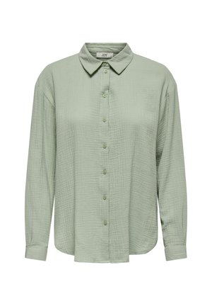 Button-up shirt in light green, made of textured fabric. Features a collar, long sleeves, and a front button closure.