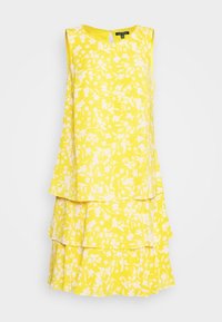 Gul ärmlös klänning med lager av volanger, med ett vitt blommönster. Har rund halsringning och dold dragkedja bak.