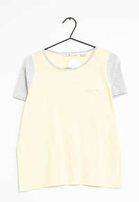 Kortärmad skjorta med en gul kropp och grå ärmar, med rund halslinning och en liten logodetalj nära fållen.