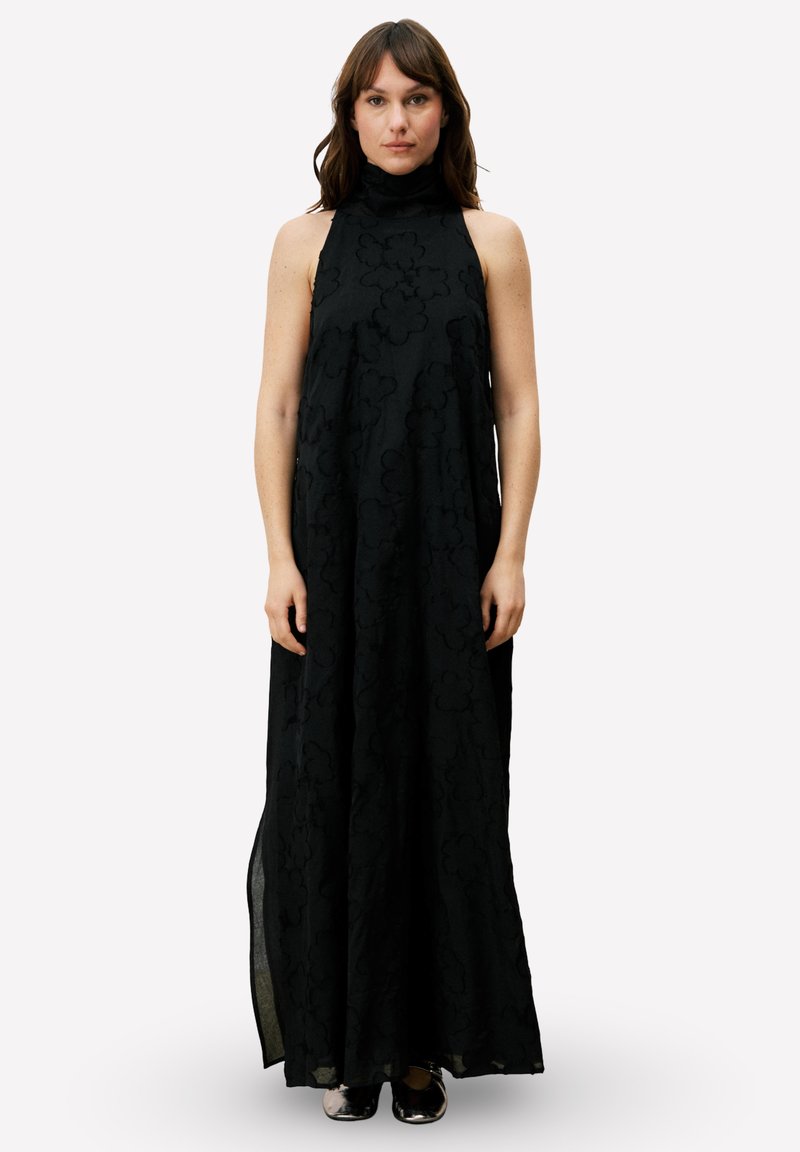 Zwarte maxijurk met een hoge hals, gemaakt van een gestructureerde stof met bloemmotieven. Losvallend ontwerp met dubbele splitten aan de zijkanten voor bewegingsvrijheid.