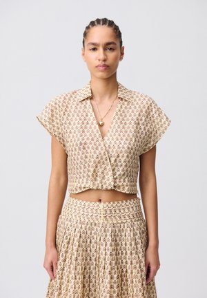 Blusa corta con motivo floreale in beige, con maniche corte e colletto, abbinata a una gonna plissettata coordinata. Texture liscia e dettagli con bottoni.