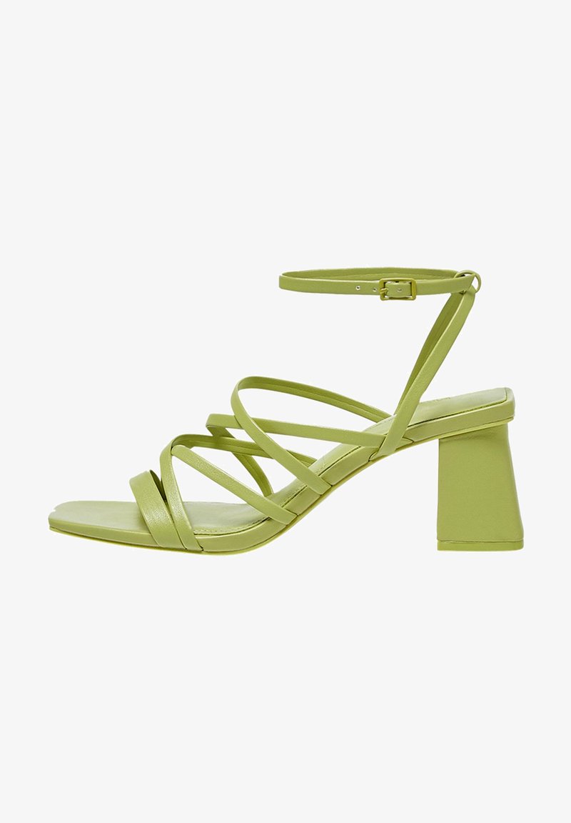 Sandalo con tacco a blocco quadrato di colore verde, con cinturini sottili. Realizzato in materiale liscio, presenta più cinturini sottili che attraversano il piede e la caviglia.