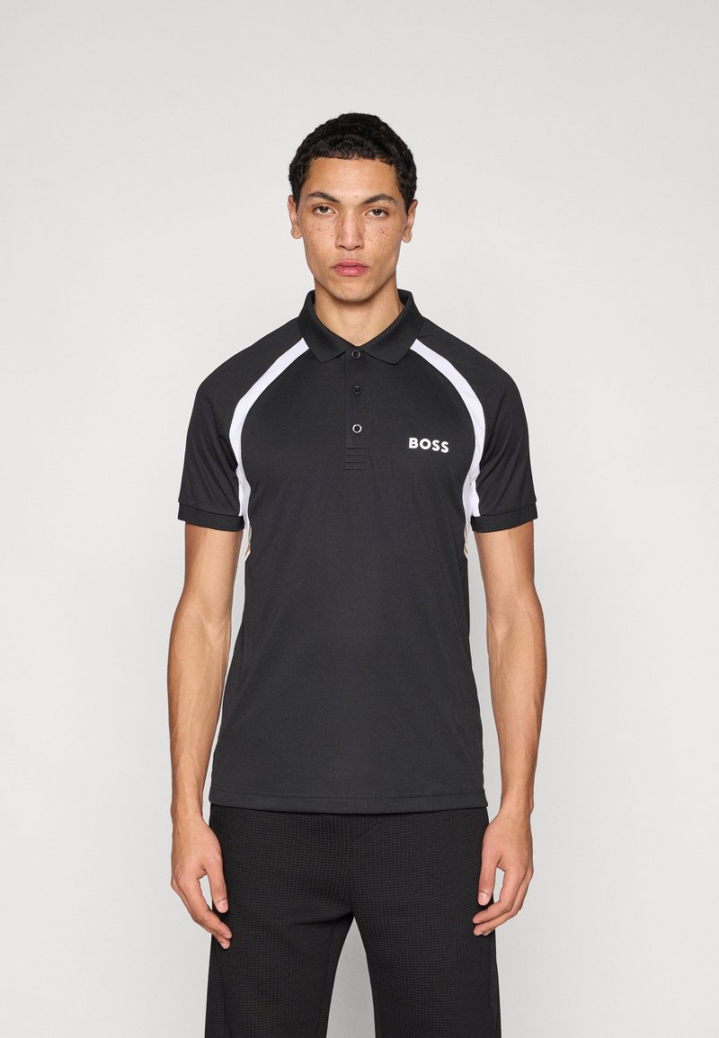 Μαύρο πόλο μπλουζάκι με λευκές λεπτομέρειες και λογότυπο στο αριστερό στήθος. Μανίκια κοντά και πατιλέτα με κουμπιά. Λεία υφή, αθλητική εφαρμογή.