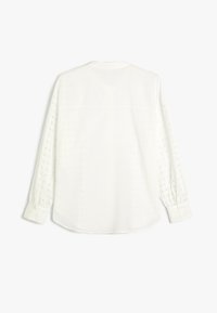 Hvid bluse med lange ærmer med hulmønstrede ærmer, knapmanchetter og en klassisk krave, vist bagfra.