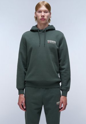 Groene hoodie met trekkoord, ribgebreide manchetten en zoom. Bevat een logo-opdruk op de borst. Gecombineerd met bijpassende joggerbroeken, ook in het groen.