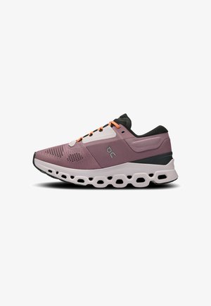 Laufschuh mit atmungsaktivem, lila Mesh-Obermaterial, schwarzen Akzenten, orangen Schnürsenkeln und einer gepolsterten weißen Sohle mit hexagonalen Ausschnitten.