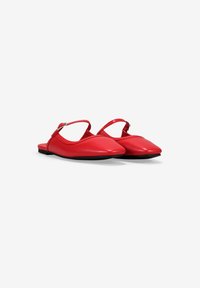 Bailarinas sintéticas rojas con tiras al tobillo, puntera puntiaguda y suela plana. Textura suave y diseño minimalista.