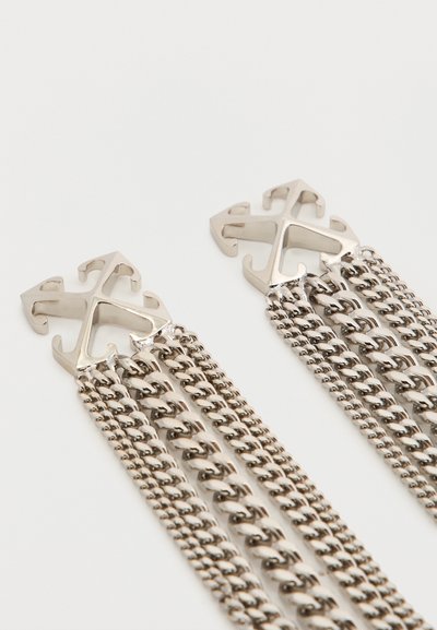 Σκουλαρίκια ασημί απόχρωσης με σχέδιο σταυρού με τέσσερα βέλη, το καθένα με πολλαπλές συνδεδεμένες αλυσίδες που κρέμονται από κάτω, σε λευκό φόντο.