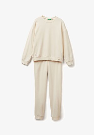 Licht beige sweatshirt en bijpassende broek van zachte stof. Het sweatshirt heeft een ronde halslijn en verlaagde schouders; de broek heeft taps toelopende benen.