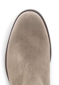 Beige suède enkelboot met een ronde neuzen, gestikte randen en een glad, lichtjes gestructureerd oppervlak. Zwarte buitenzool.
