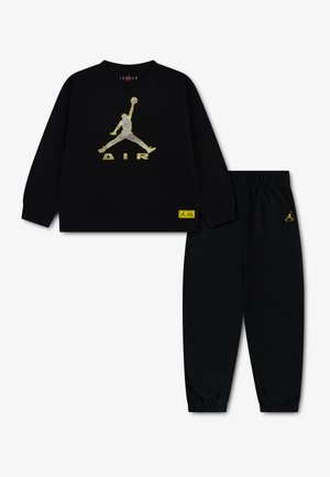 Czarna bluza Jordan z długim rękawem i pasujące spodnie z żółtym logo Jumpman oraz tekstem "Air" na piersi i spodniach.
